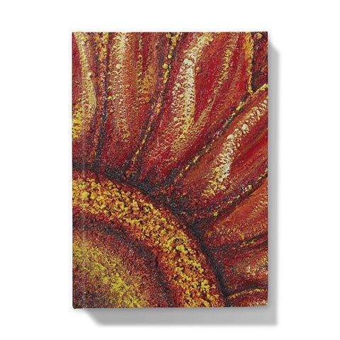 Artistic Hardback Journal Sunflower Passion with the centre of the flower in one corner and the petals reaching out towards the edges of the journal.  Beautiful rich colours of reds & golds