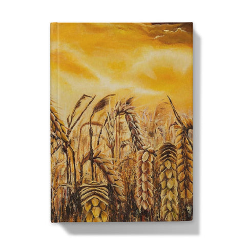 Stormy Wheat Field Hardback Journal with golden colours, auburn caramel heads of wheat & a very brightly light up stormy sky in browns & oranges & white flashes of sunlight