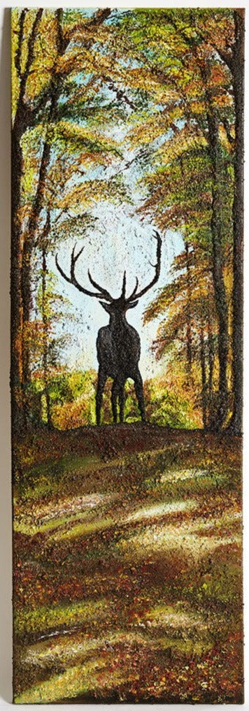 Original Canvas Wall Art A proud stag standing in the center of of path in a forest at the cusp of the path, with large antlers.  He is shadowed by tall trees either side of him and the light from behind.  Blue sky above the autumnal leafed forest.  Light coming through the trees casts light on the path before him with colourfull leaves that have fallen to the ground.