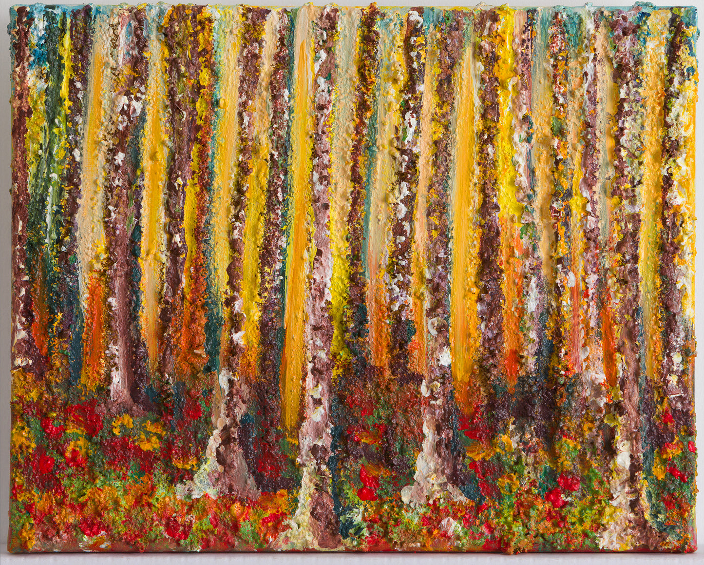 Wall Art Canvas Print Small Wood A colourful textured painting of a wood, with lots of trunk reaching to the top of the canvas.  The bark on the trees are very textured and the light between the trees changing from yellows or warmer oranges.  The blue sky hinting at the top of the trees.  The forest floor is a carpet of colours as the leaves have fallen to the ground