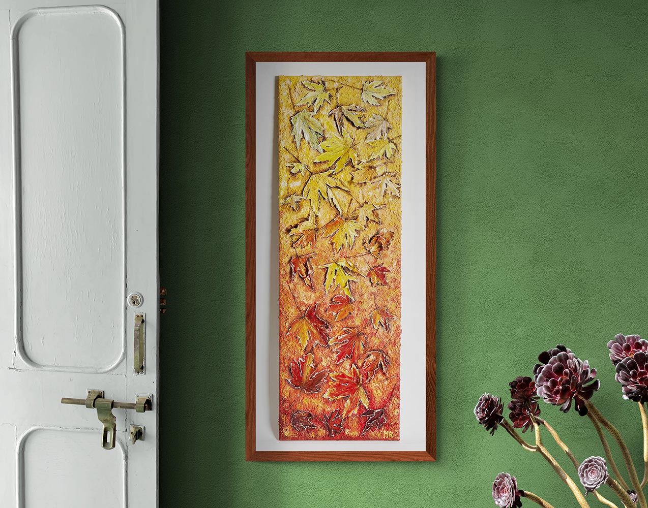 Canvas print wall art tumbling leaves of autumn.A long paining of tumbling maple leaves, staring at the top with light hints of green & yellos through to stronger yellows & golds to auburns to oranges, burnt oranges & reds through to stronger reds & mauve's, hung on a dinning room wall with a wooden frame.